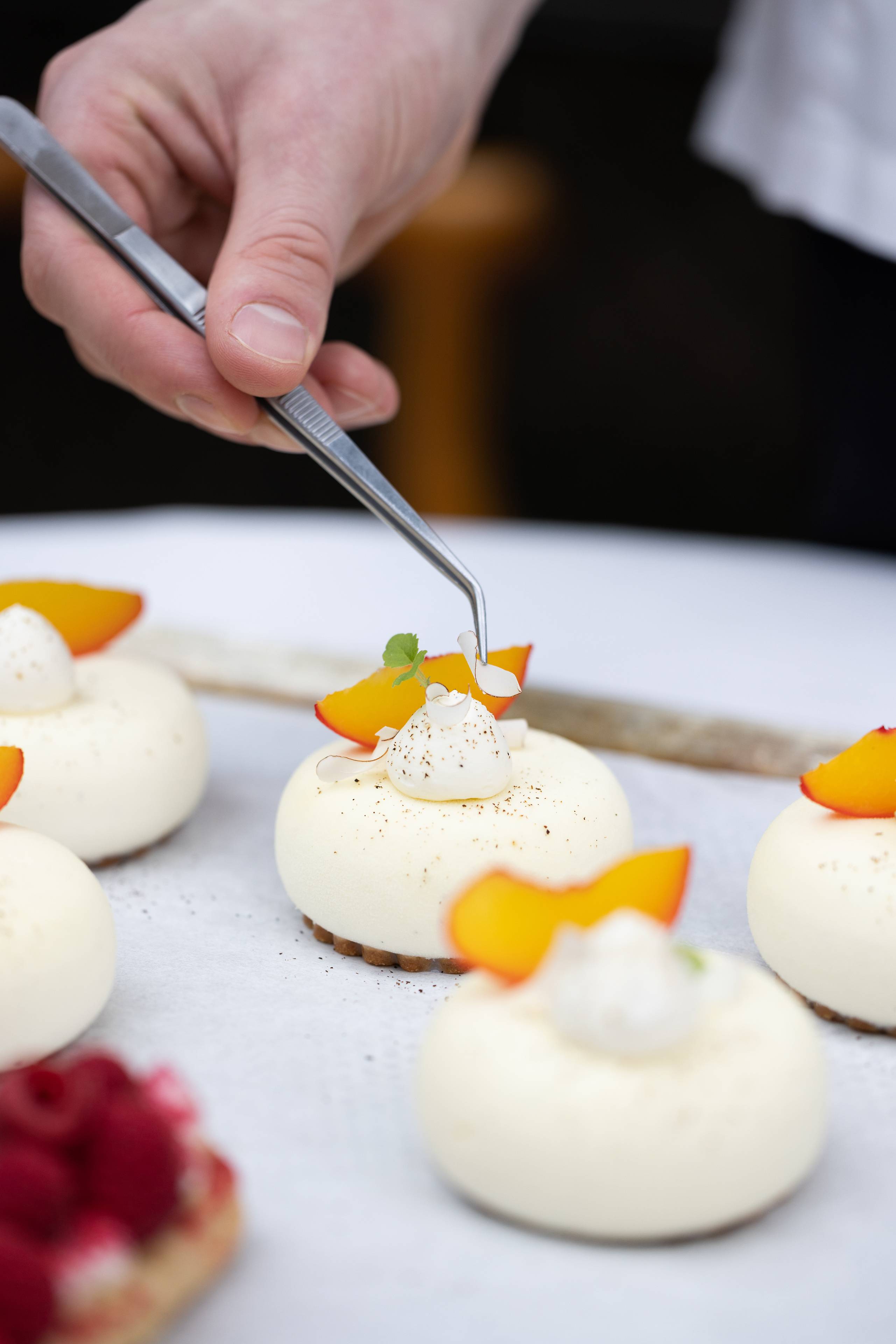 Decorating mini cakes with gin, peach and fromage blanc