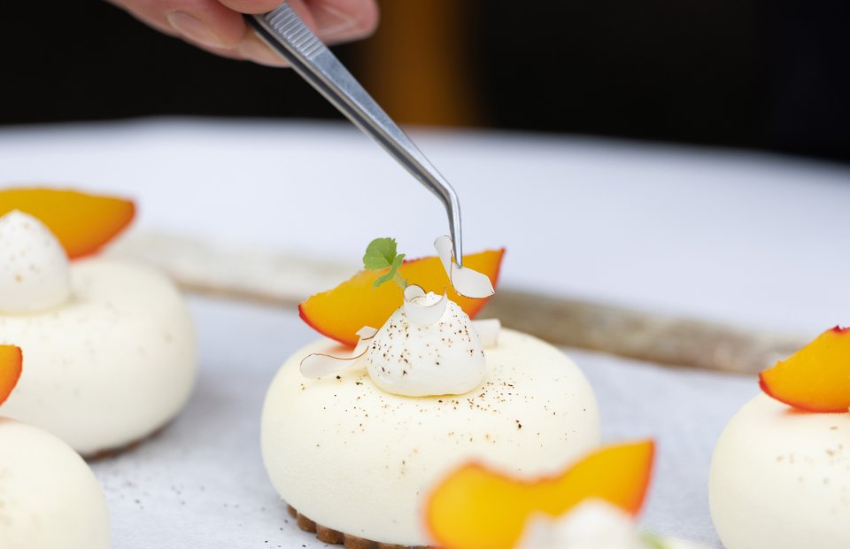 Decorating mini cakes with gin, peach and fromage blanc